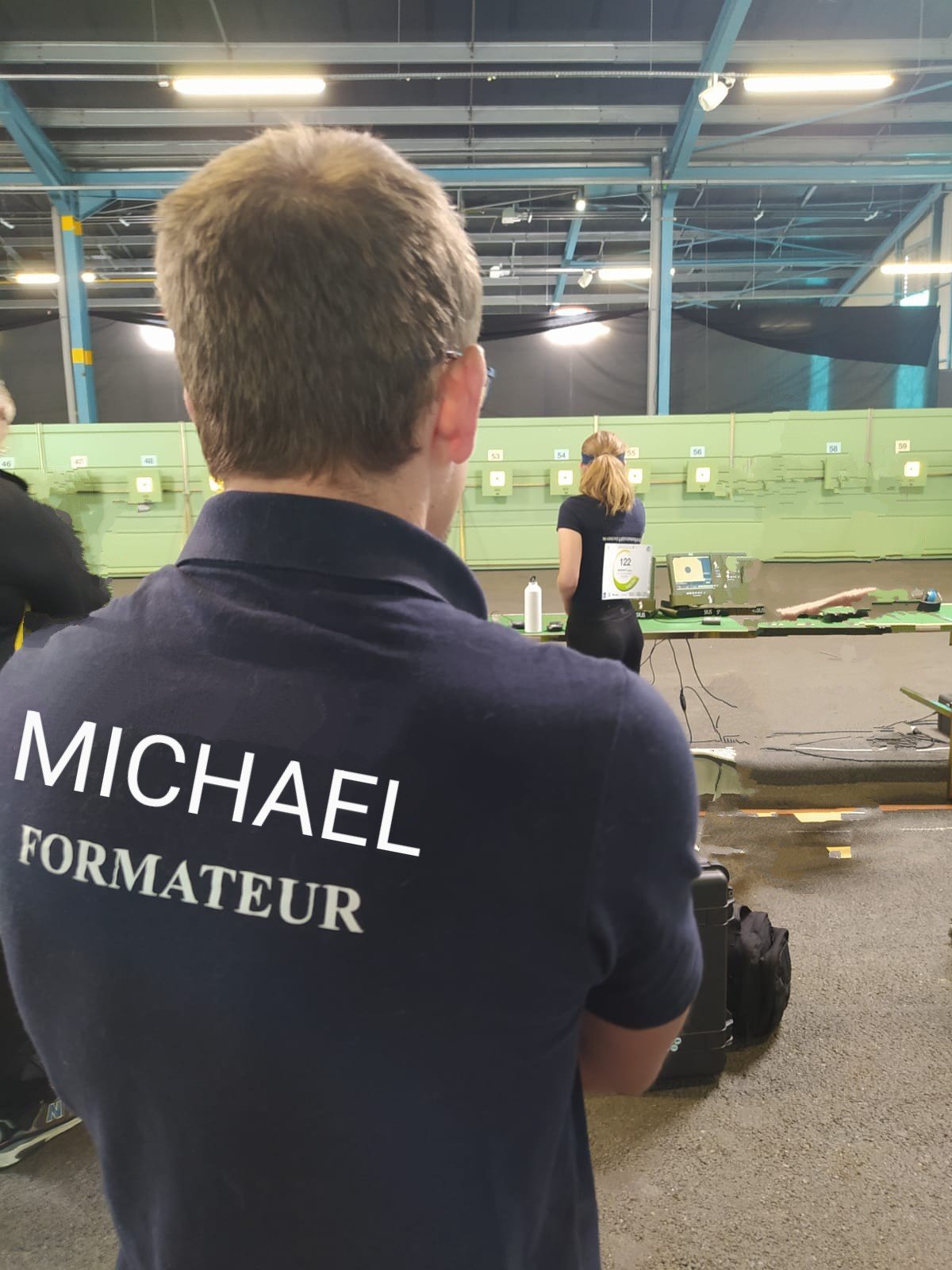 Michaël de dos, avec son polo Formateur, lors d’un accompagnement en compétition